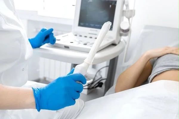 Profissional realizando ultrassonografia transvaginal em consultório ginecológico