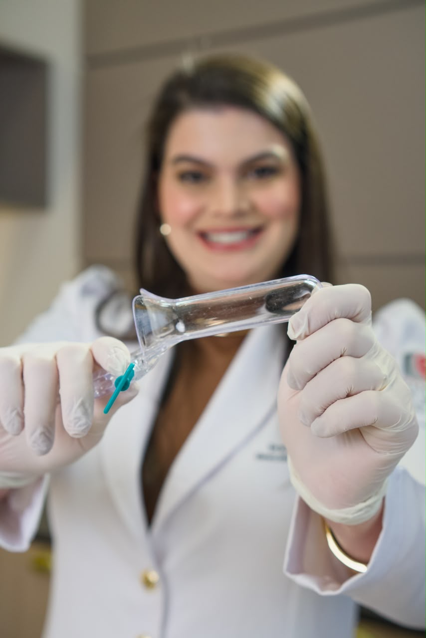 Dra. Iara Tomaz em consultório ginecológico com especulo para exame Papanicolau